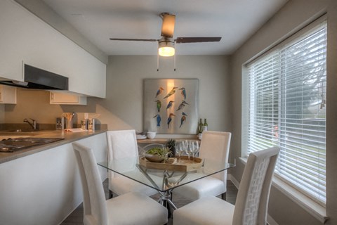 a kitchen and dining room with a glass table and chairs