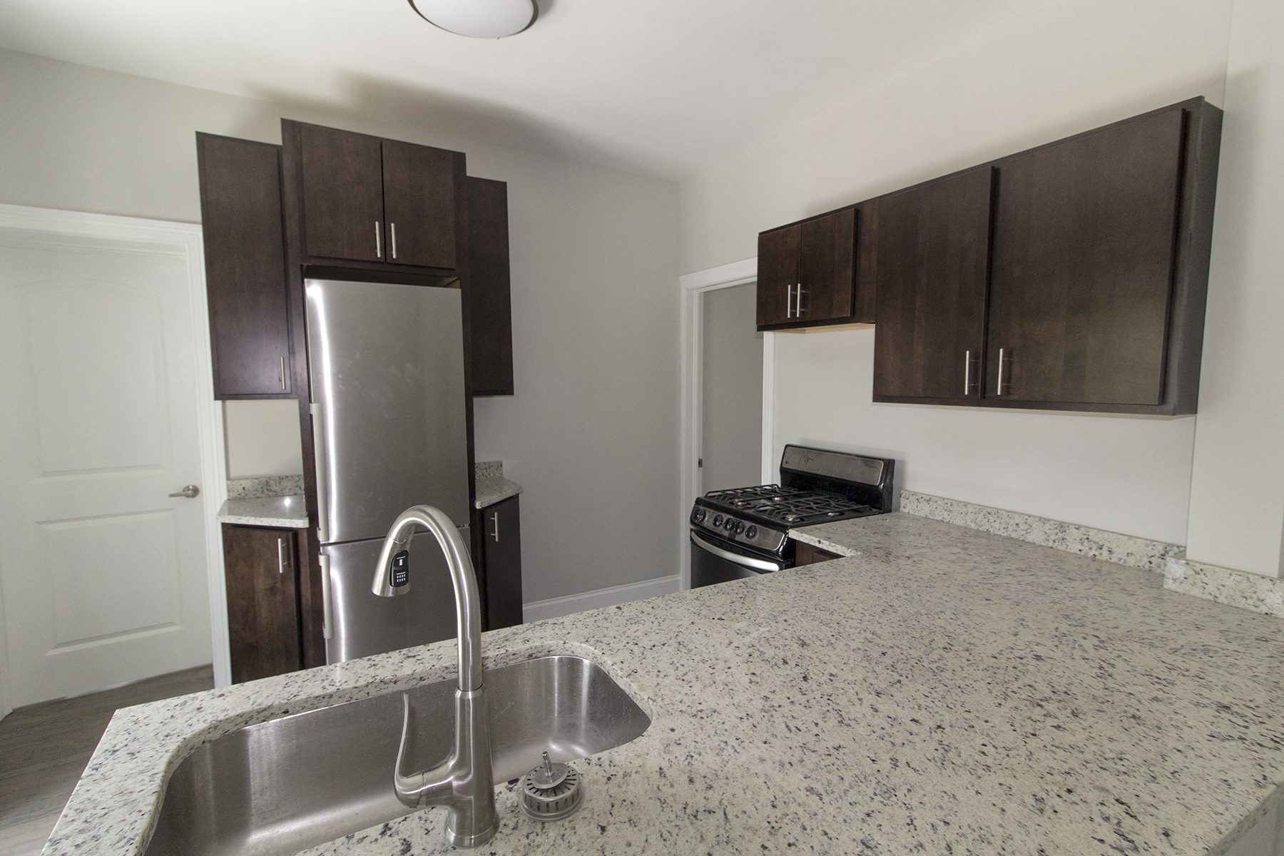 a kitchen with a granite counter top and a stainless steel refrigerator