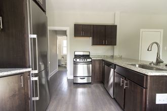 an empty kitchen with wooden cabinets and stainless steel appliances