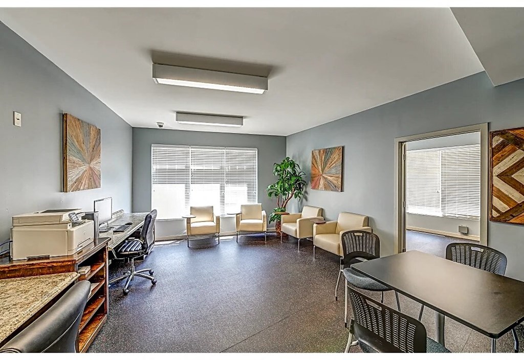 an office space with a desk and chairs and a printer