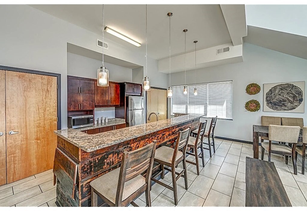 a large kitchen with a long bar with chairs