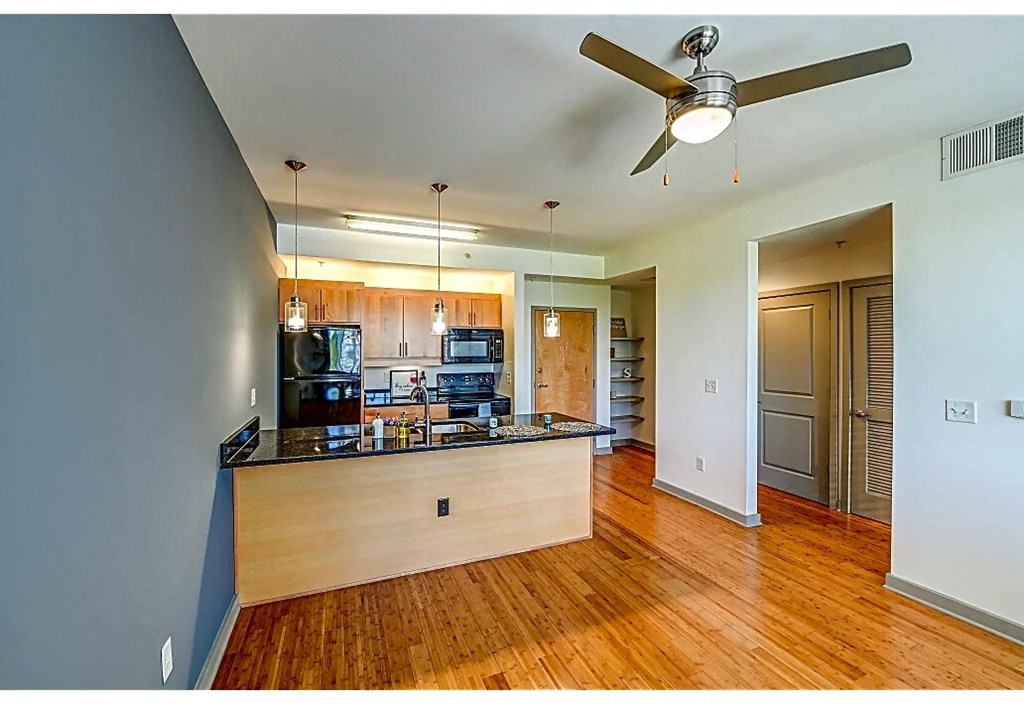 a kitchen with a large island and a ceiling fan