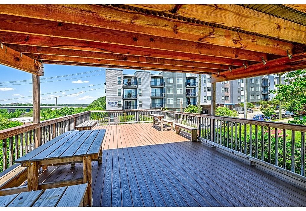 a large deck with benches and a wooden roof