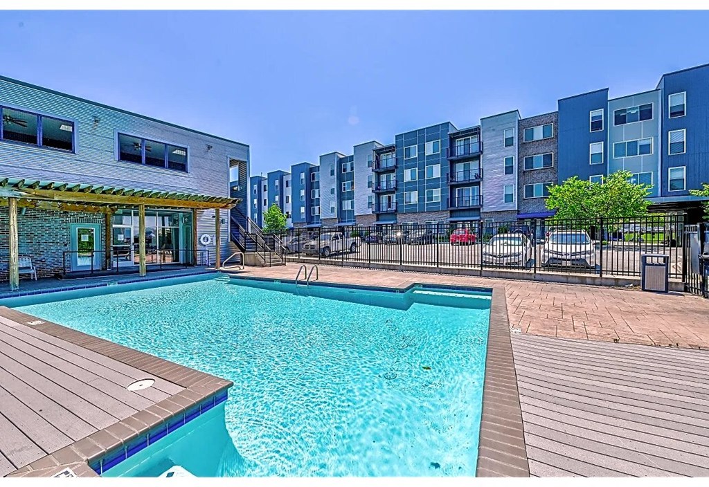 a swimming pool is next to an apartment building