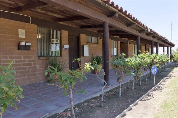 a building with a porch and trees in front of it