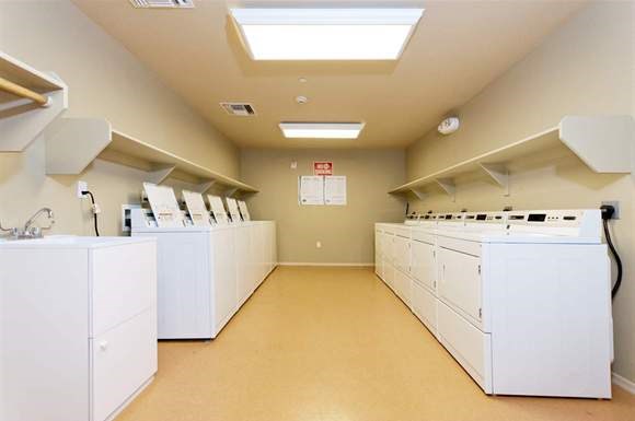 a row of white washing machines in an empty room