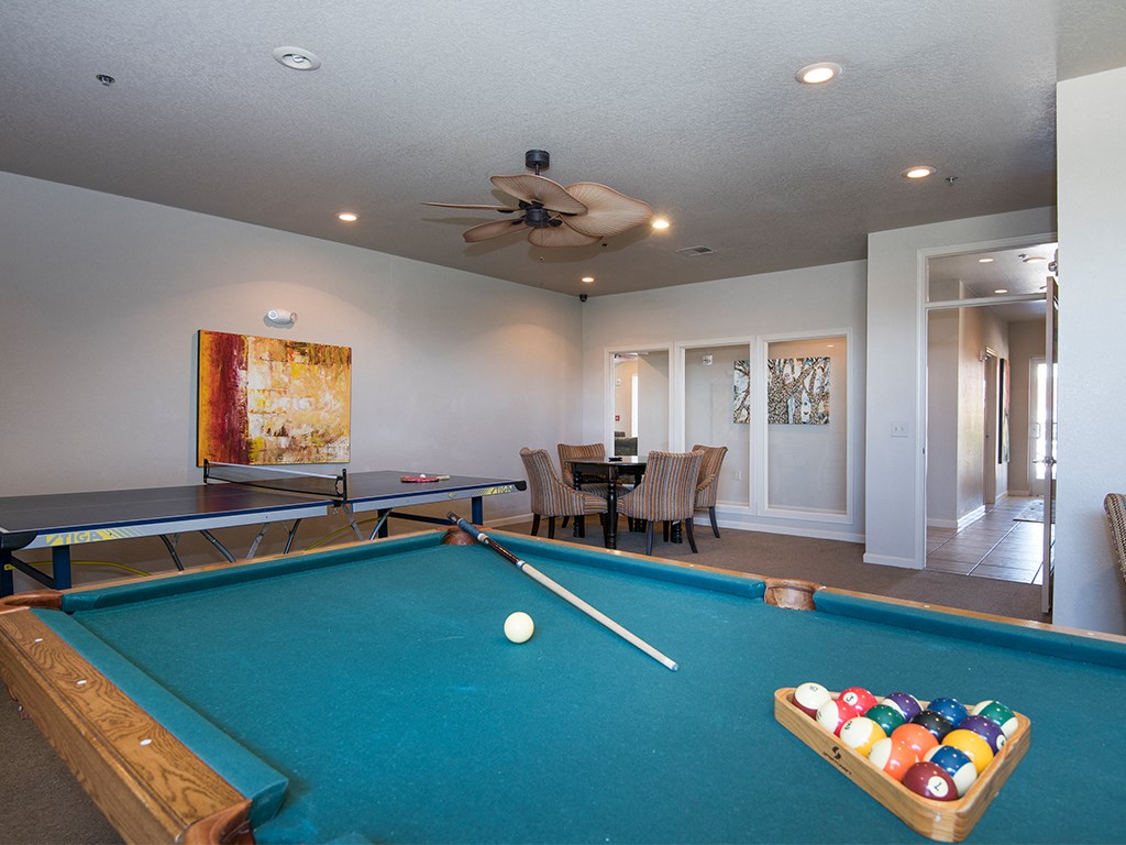 a game room with a pool table and a ceiling fan
