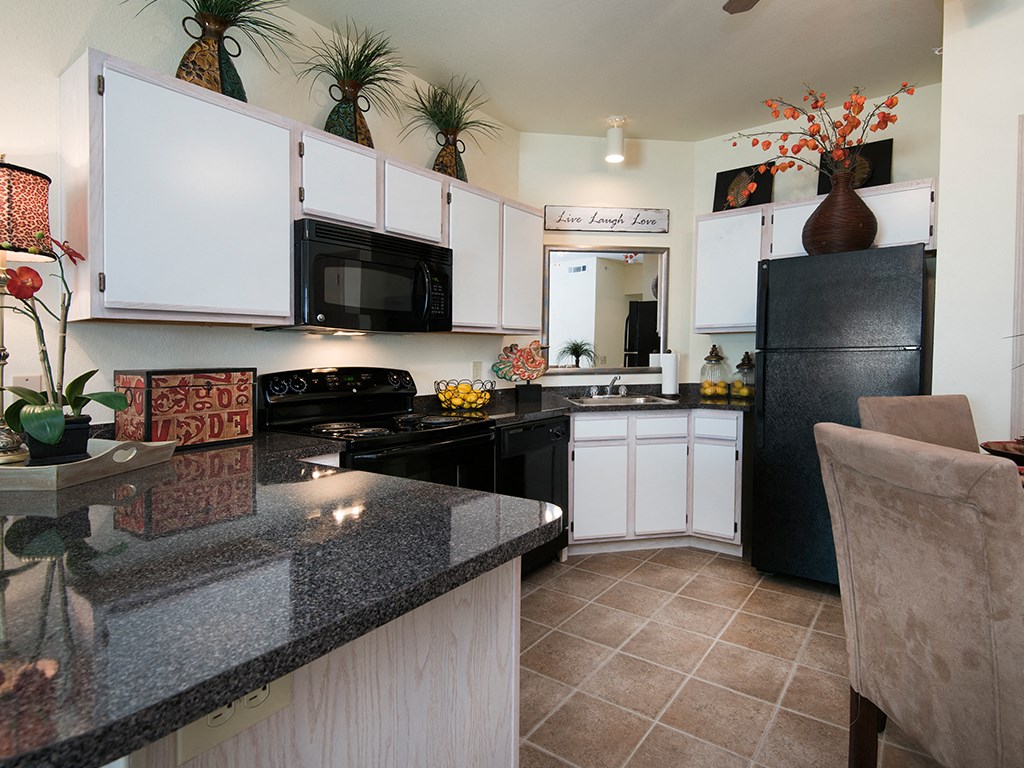 a kitchen with black appliances and granite counter tops
