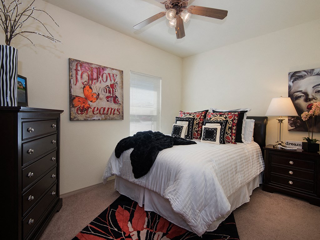 a bedroom with a bed and a ceiling fan