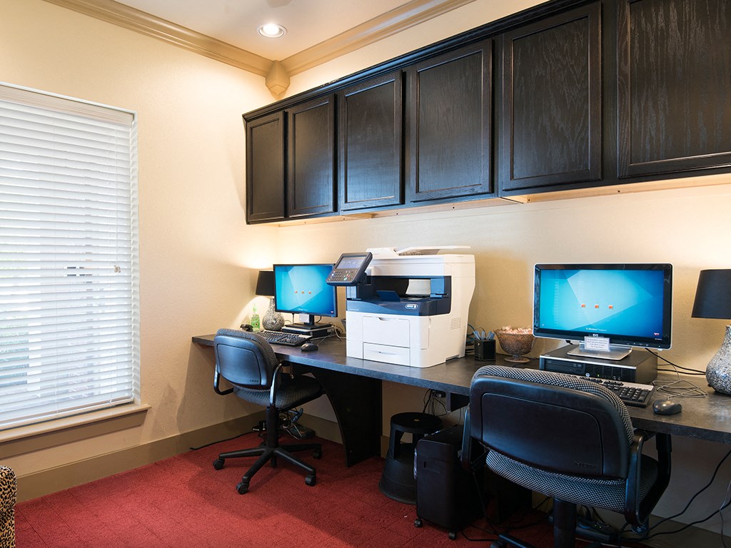 a home office with two computers and a printer