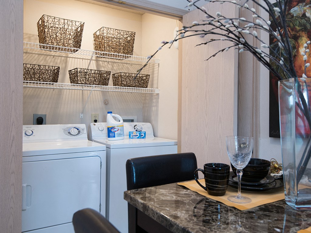 a laundry room with a washer and dryer and a counter with a sink