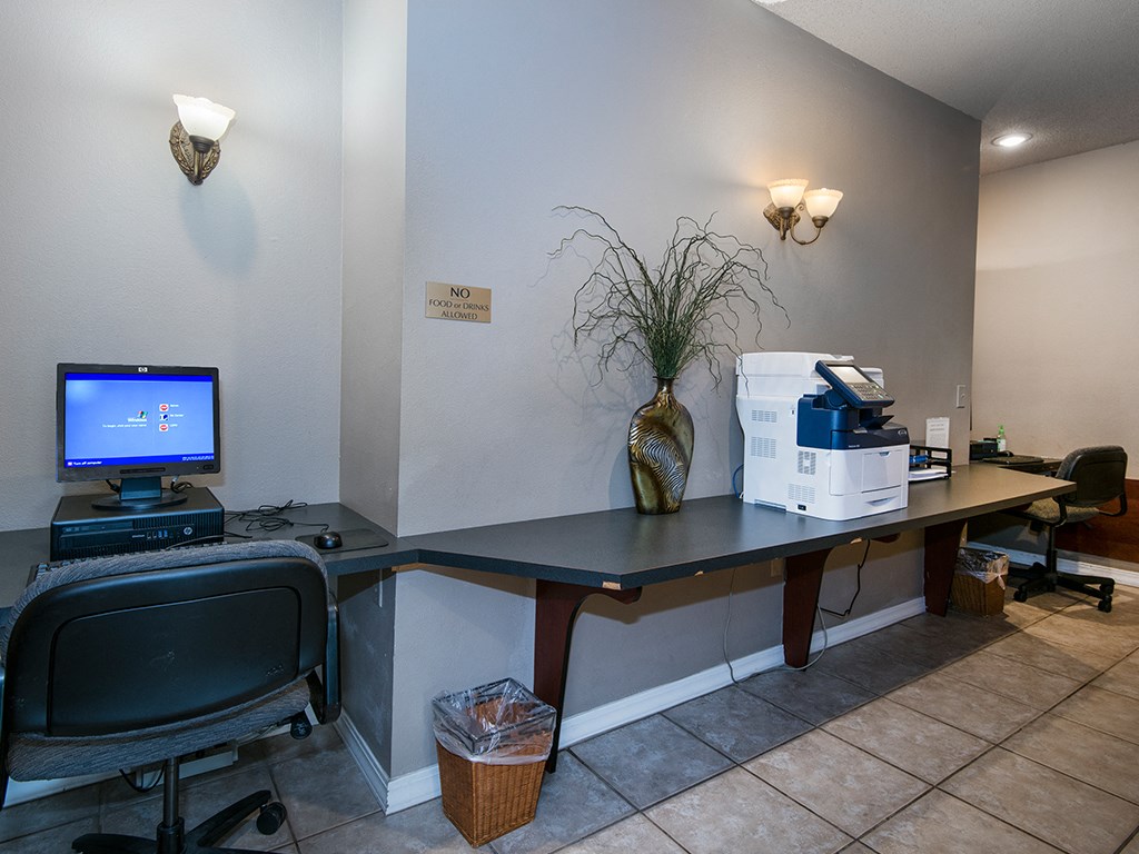 a home office with a computer and printer on a desk
