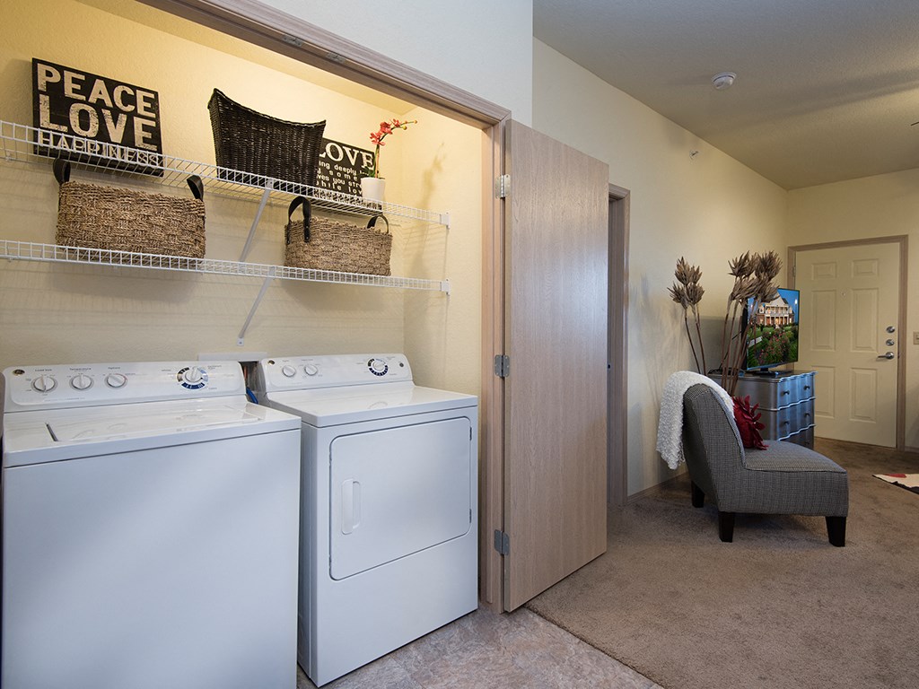 a laundry room with a washer and dryer and a door to a closet