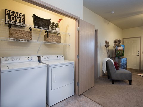 a laundry room with a washer and dryer and a door to a closet