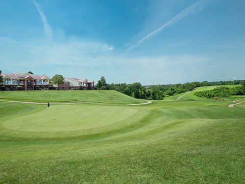 a view of a golf course with houses in the background