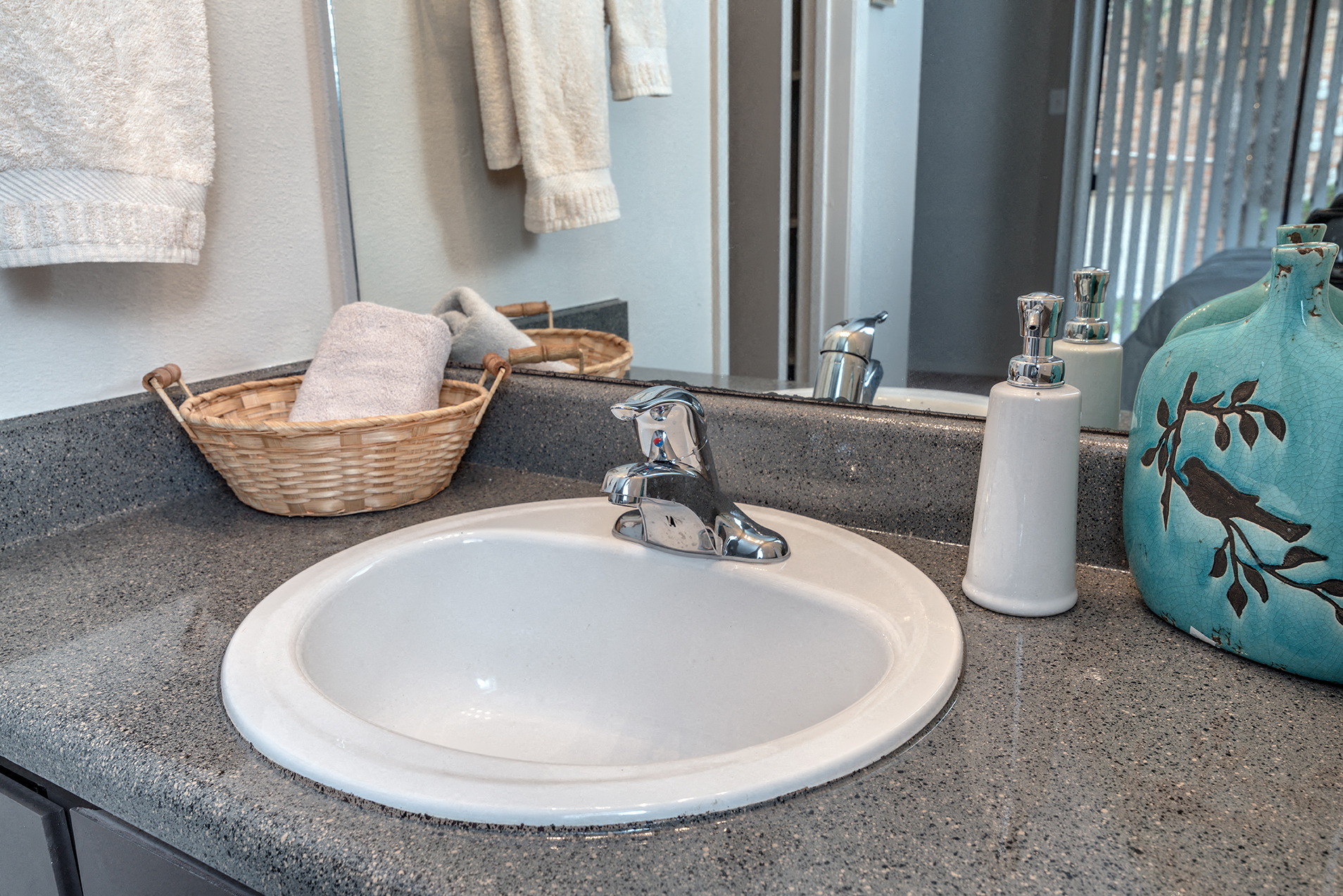 a bathroom sink with a mirror and a basket with towels