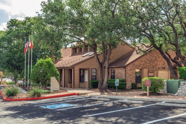 a building with a flag and trees in front of it