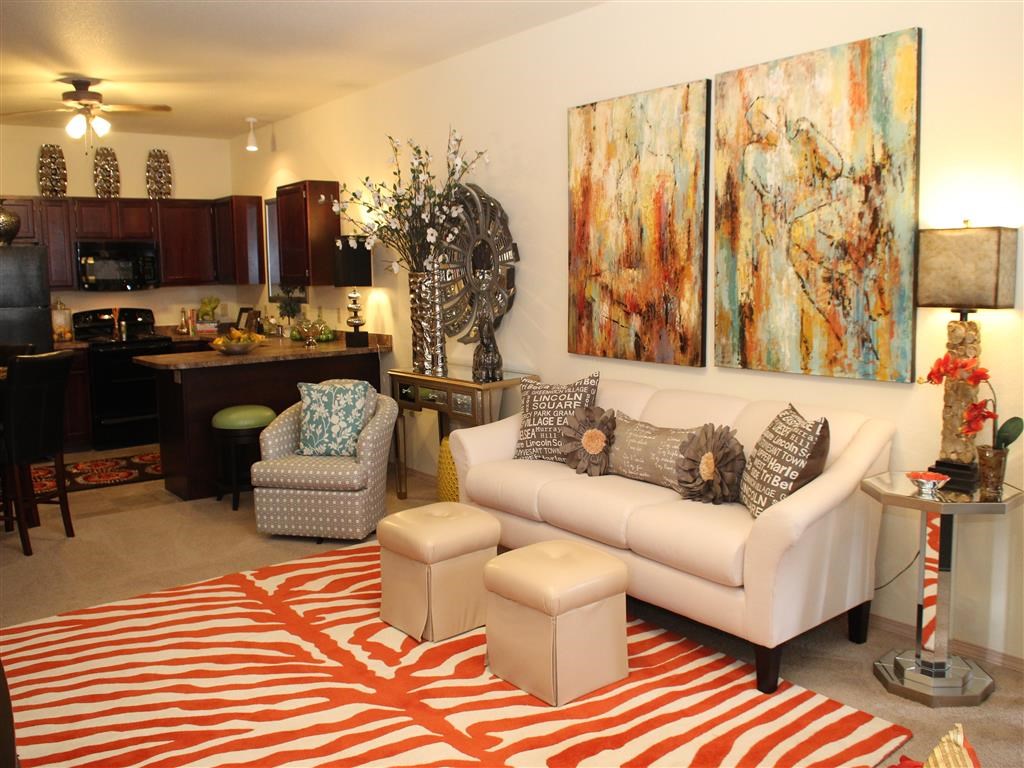 a living room with a couch and chairs and a kitchen