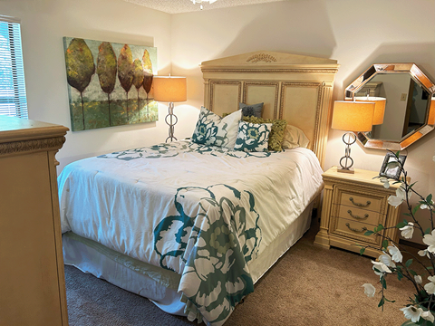 a bedroom with a bed and two lamps and a dresser