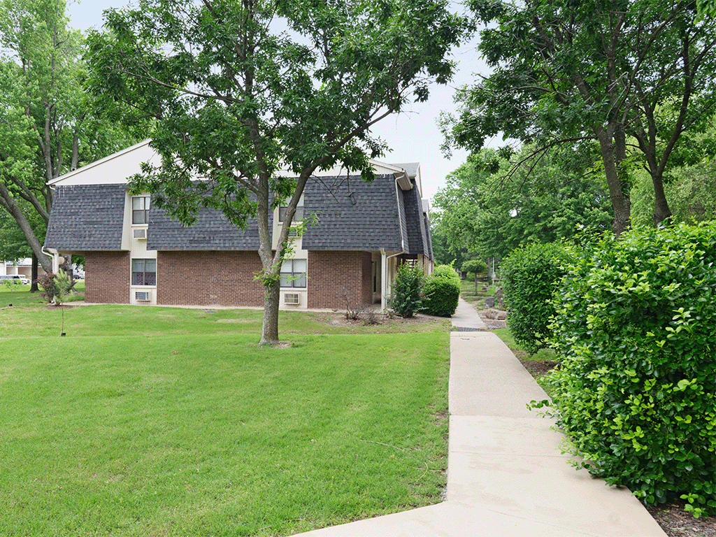 a brick house with a yard and a sidewalk