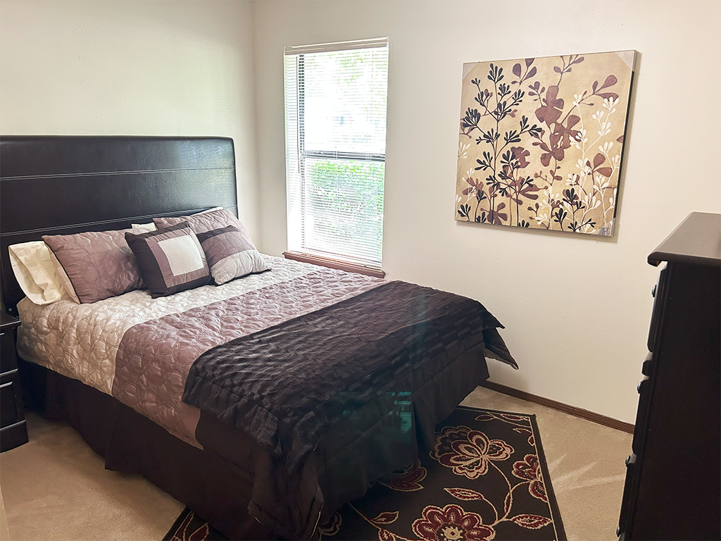 a bedroom with a bed and a painting on the wall