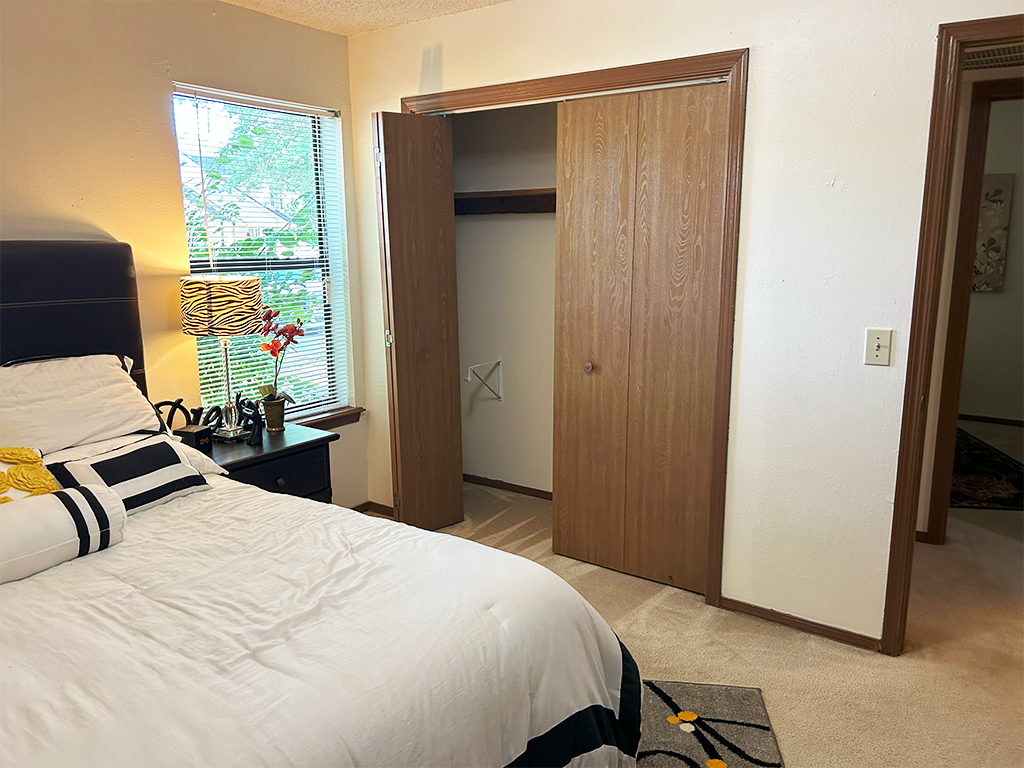 a bedroom with a closet and a bed and a window