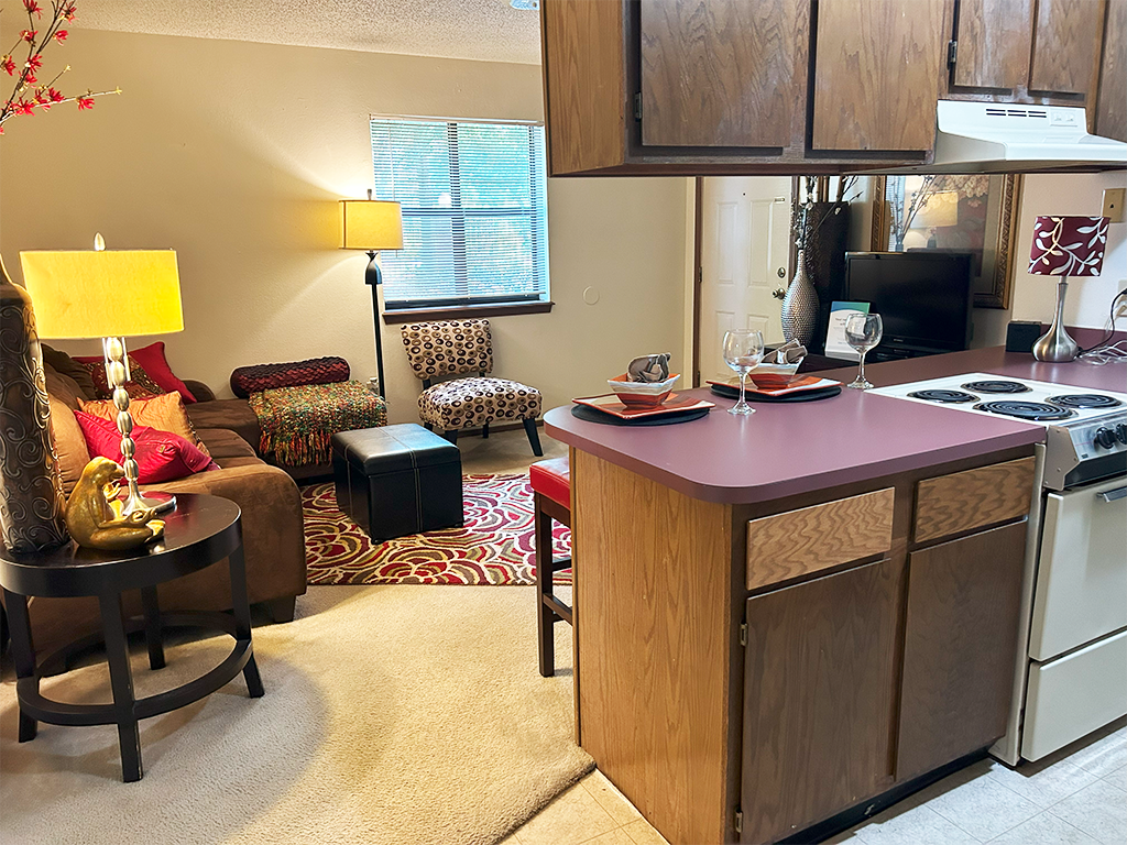 a kitchen and living room with a stove and a table