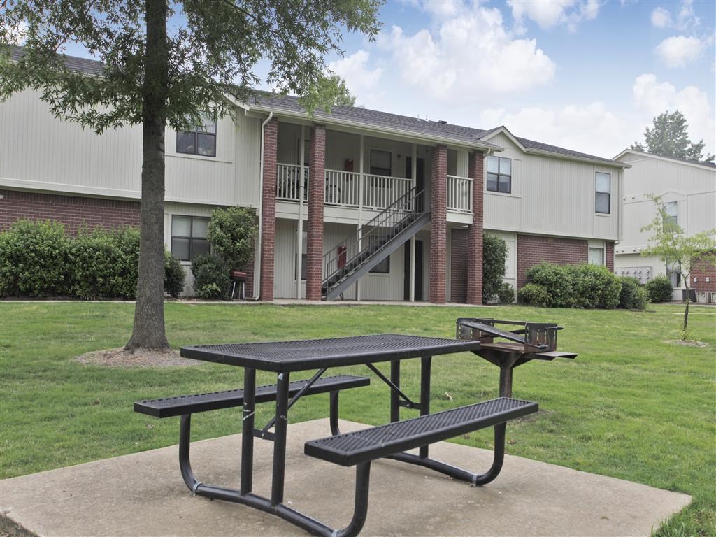 two picnic tables in front of an apartment building
