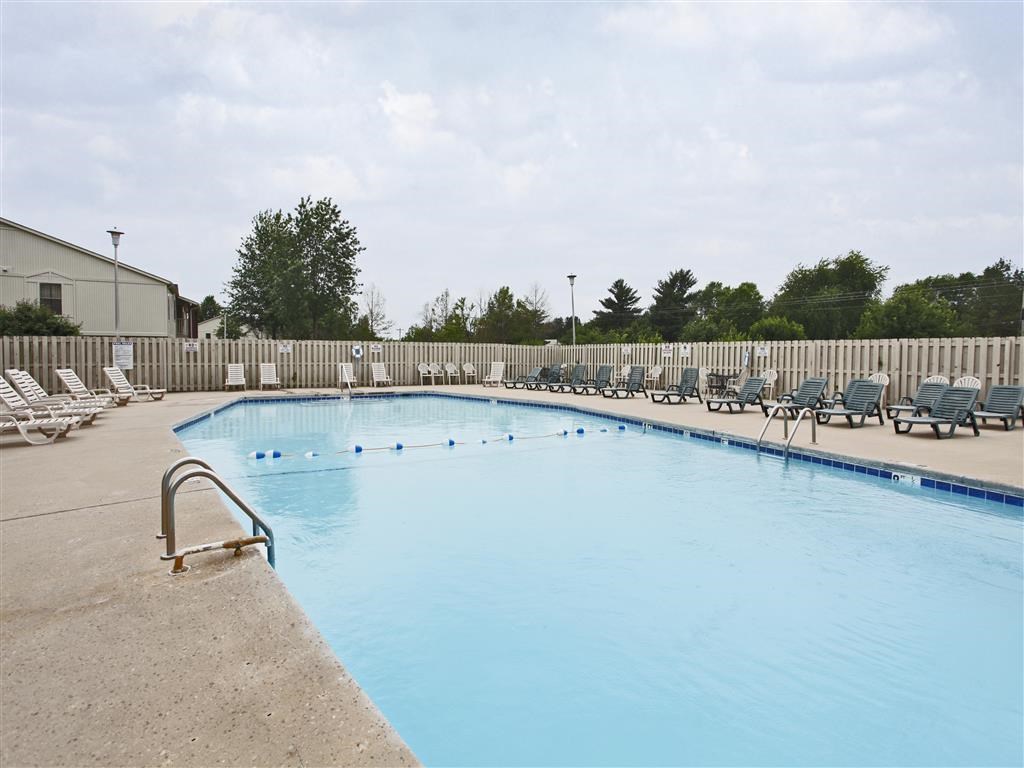a swimming pool with chairs and a fence around it
