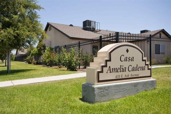 a sign in the grass in front of a house