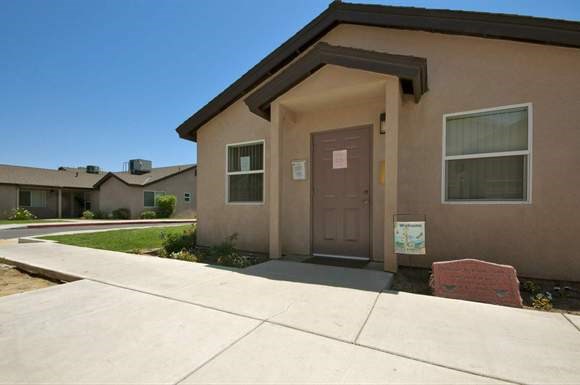 a brown house with a brown door and a sidewalk