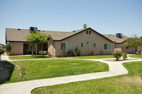 a house with a lawn and a sidewalk in front of it