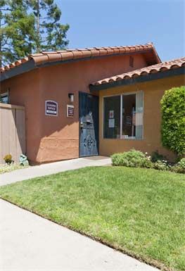 a brown building with a blue door and a lawn