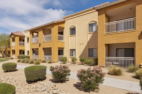 an apartment building with a courtyard and bushes