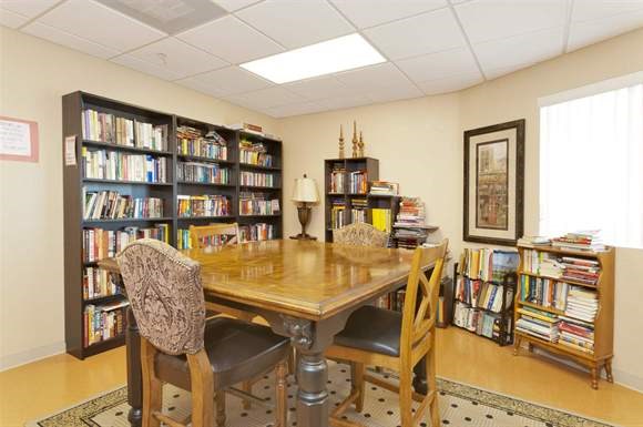 a library with a table and chairs and bookshelves