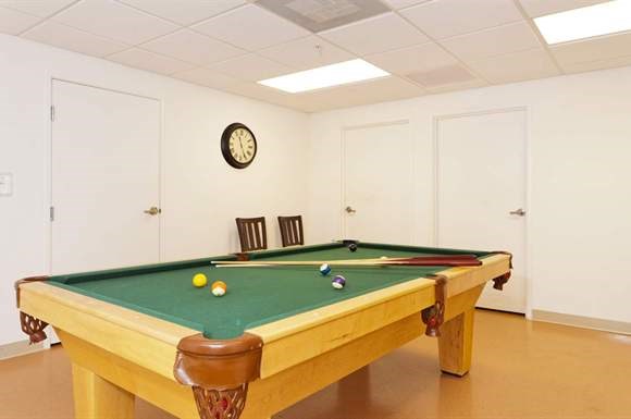 a pool table in a room with two chairs