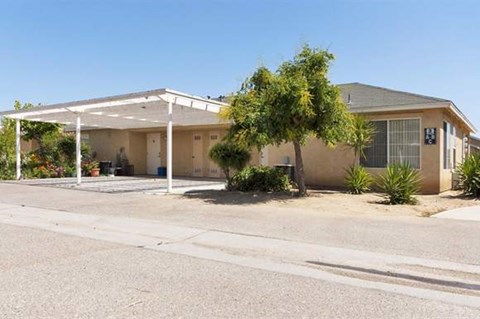 a house with a covered porch in a parking lot