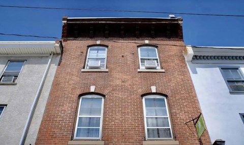 A red brick building with three windows.