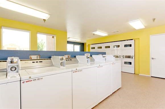 a laundry room with a row of washing machines