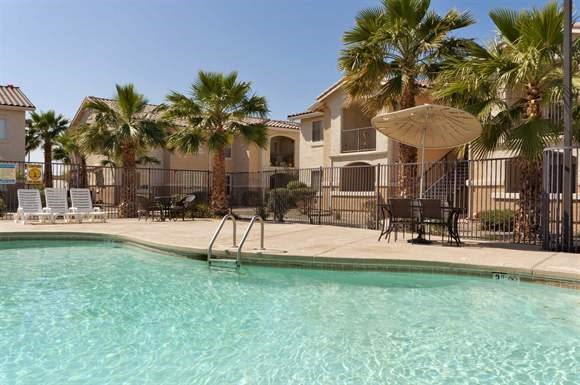 a swimming pool with chairs and an umbrella