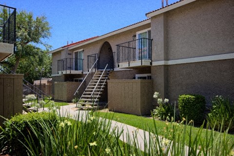 a building with a staircase and a yard in front of it