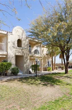 a house with a yard and trees in front of it