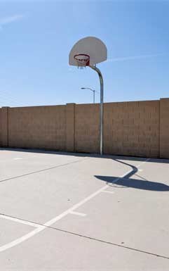 a basketball hoop on a court in front of a blue sky