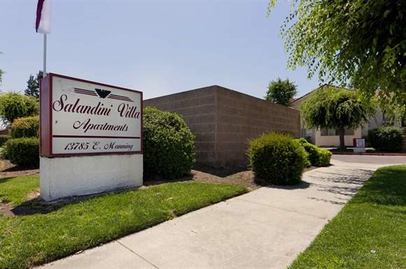 a sidewalk in front of a building with a sign