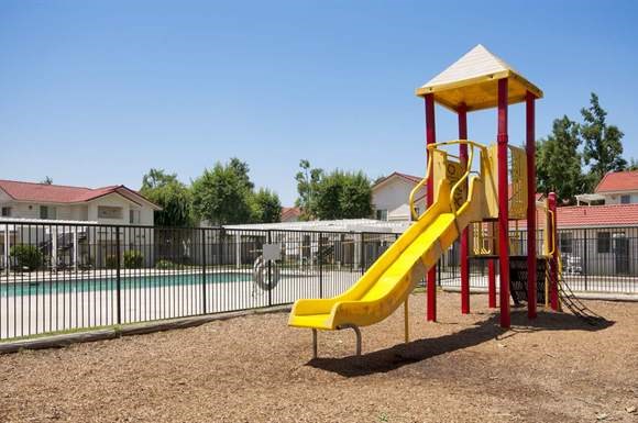 a playground with a yellow slide  and a pool
