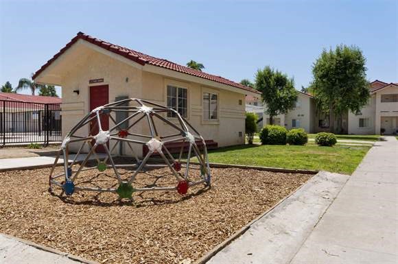 a yard with a swing set in front of a house