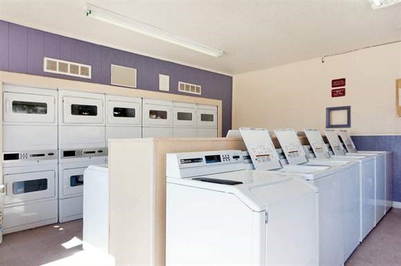 a group of washers and dryers in a laundromat