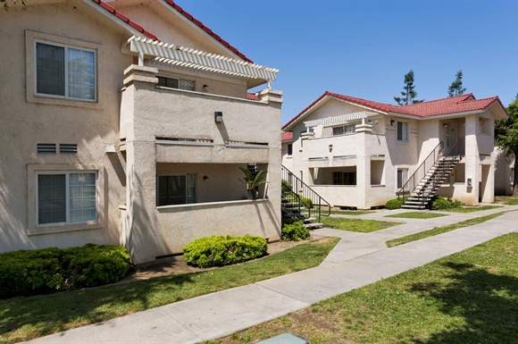 a row of houses with stairs and a sidewalk