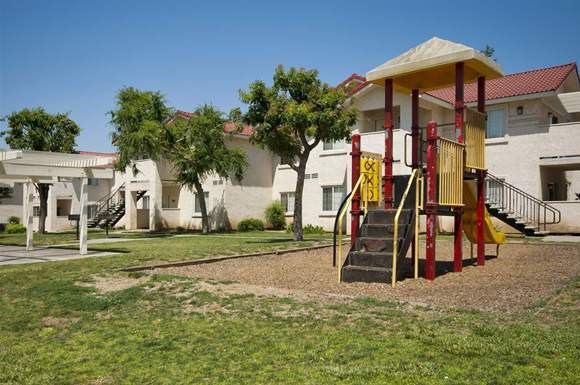 a yellow and red swing set in a playground
