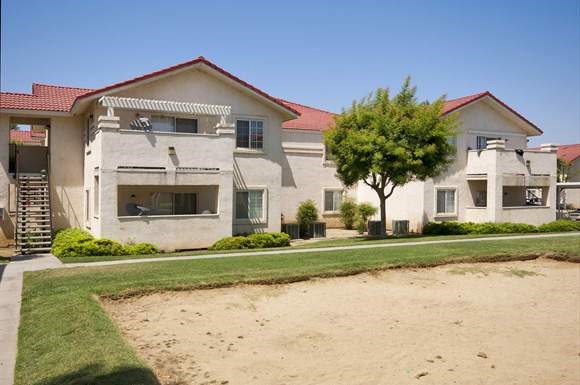 a white house with a dirt field in front of it